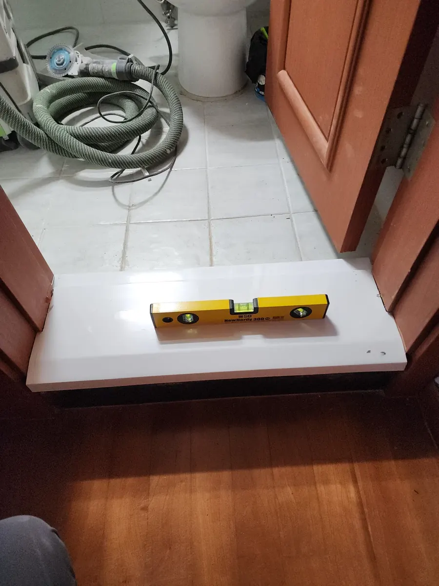 욕실 문턱 보수 — 새 문턱 위에 올린 수평자