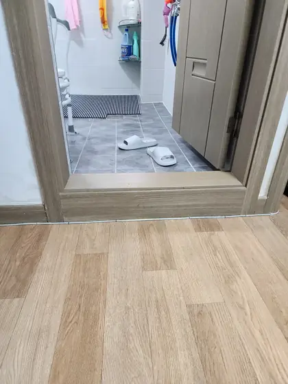 문지방 낮추기 — 거실 바닥보다 높게 올라온 나무무늬 문지방